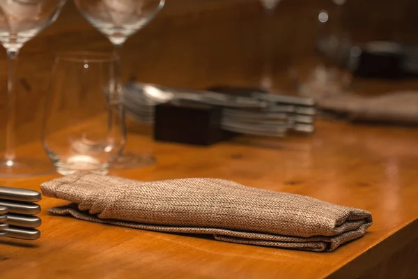 Gefaltete Serviette auf dem Holztisch im Restaurant — Stockfoto