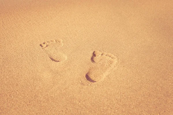 Stempel van voeten op zand op het strand met zon in de ochtend, — Stockfoto
