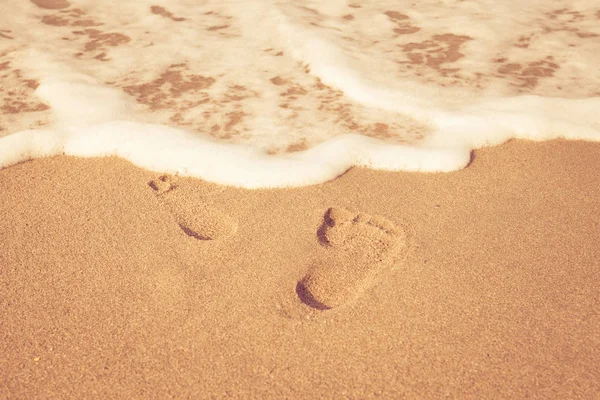Pieczęć stóp na piasku na plaży w promieniach słońca na rano, — Zdjęcie stockowe