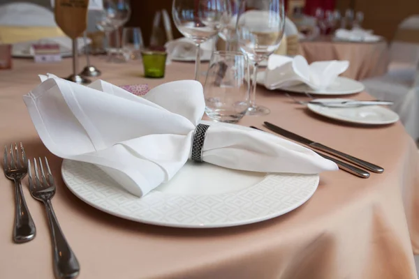 Einrichtung des Abendessens im Hotel. gefaltete Serviette auf Teller gelegt auf — Stockfoto