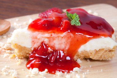 Ahşap masa üzerinde ahşap plaka üzerinde çilek pasta kadar kapatın.