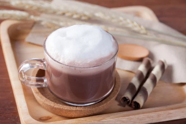 Cerrar la leche de chocolate caliente con merienda en plato de madera en madera — Foto de Stock