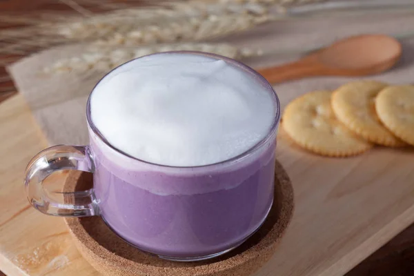 close up hot purple milk with biscuits on wooden plate on wooden