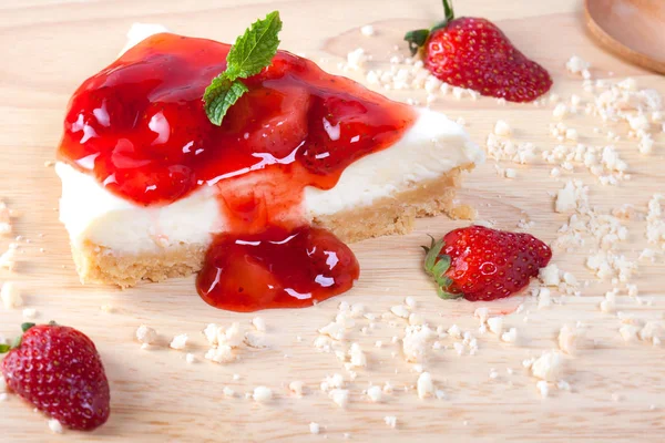 Ahşap masa üzerinde ahşap plaka üzerinde çilek pasta kadar kapatın.