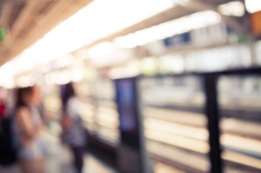 Arka plan bulanık yürüyüş ve vintage renk stili ile elektrikli tren istasyonunda duran insanlar birçok soyut.