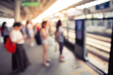 Arka plan bulanık yürüyüş ve vintage renk stili ile elektrikli tren istasyonunda duran insanlar birçok soyut.