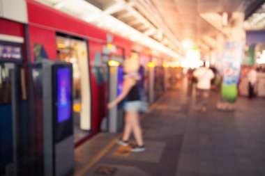 Arka plan bulanık yürüyüş ve vintage renk stili ile elektrikli tren istasyonunda duran insanlar birçok soyut.