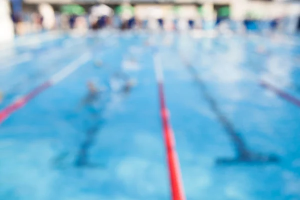 模糊的背景的学生游泳比赛在游泳池里. — 图库照片