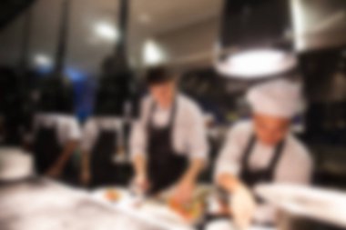 Şef otel ya da Restoran mutfak pişirme bulanık arka plan