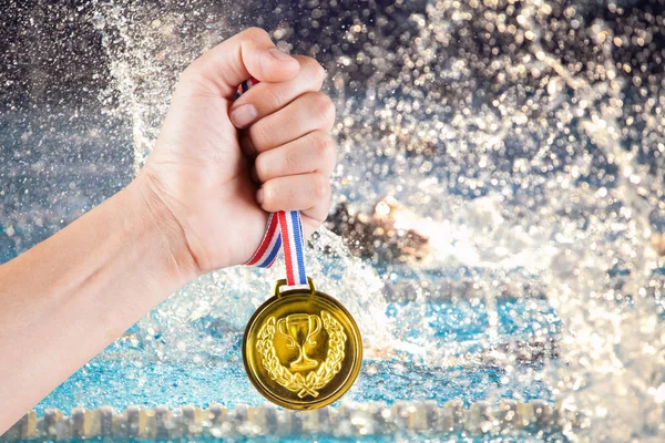 Puñado de asiático hombre celebración de la medalla de oro con fondo borroso de la piscina y la competencia de natación . — Foto de Stock