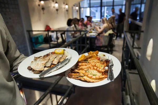 Izgara karides Hindistan ile hizmet veren Restoran, bulanık arka plan lüks parti gıda garson.