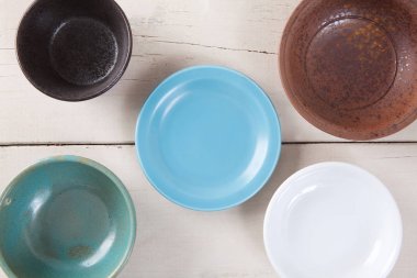 Beyaz ahşap masanın üstüne koy boş renkli plaka Üstten Görünüm.