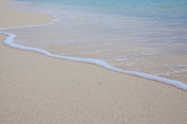 Yumuşak dalgalar ile kumlu plaj arka plan.