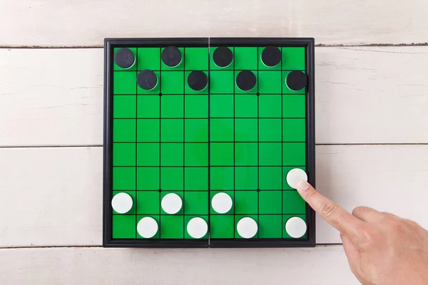 Start checker game on green board view from above on wood table.