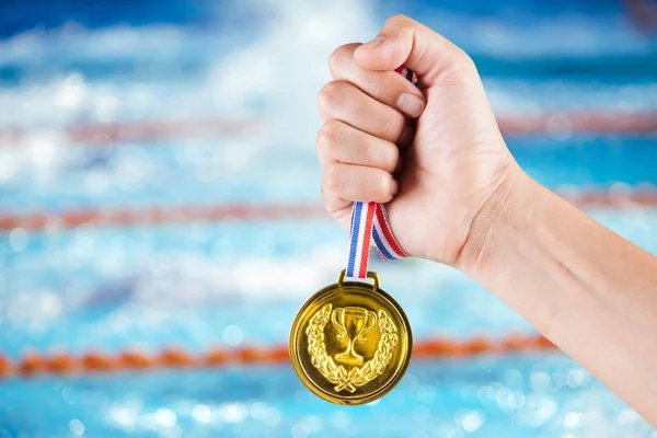 Puñado de asiático hombre celebración de la medalla de oro con fondo borroso o — Foto de Stock