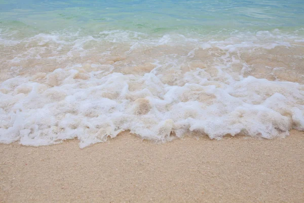 Fondo borroso abstracto de ola suave de mar azul con playa de arena . — Foto de Stock