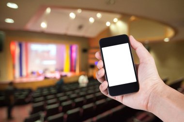 El ve beyaz perde tiyatro bulanık arka plan ile Smartphone.