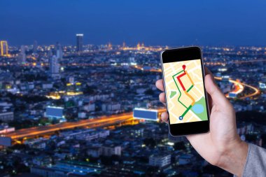 Smartphone uygulama ile cityscape arka plan harita kullanarak adamın elini.