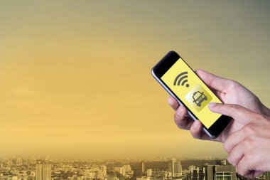 Smartphone telefon taksiyle uygulama smartphone ve cityscape arka plan ile ağ wifi kullanarak adamın elini.