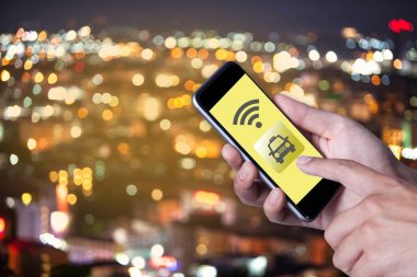 Smartphone telefon taksiyle uygulama smartphone ve bokeh arka planını yolda araba ile ağ wifi kullanarak adamın elini.