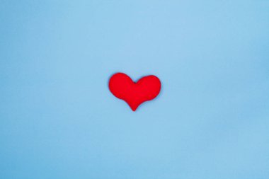 Kopyalama yeri olan üst görünümden mavi arka plan üzerinde kırmızı kalp. Sevgililer günü kavramı.