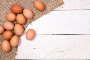 Kopya için alanı olan torba üzerinde ahşap masa üzerinde tavuk yumurta.
