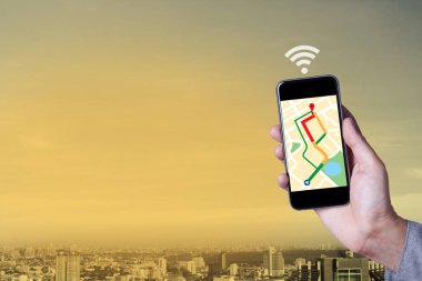 Smartphone uygulama ile cityscape arka plan harita kullanarak adamın elini.
