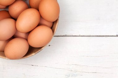 Tavuk yumurta kopyalama yeri olan ahşap masa üzerinde ahşap kase 