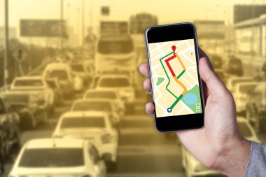 Harita üzerinde trafik sıkışıklığı ile smartphone uygulama kullanarak adamın elini