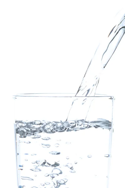 Drinking water gieten in glas op witte achtergrond. — Stockfoto