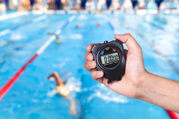 Cronómetro en la mano con competiciones de fondo de natación . — Foto de Stock