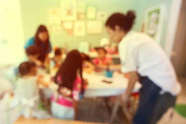 Verschwommener Hintergrund des Lehrers, der Kinder im Kunstunterricht unterrichtet. — Stockfoto