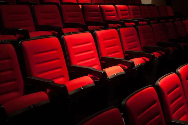 Red seat in the movie theater. Blurry background. — Stock Photo, Image