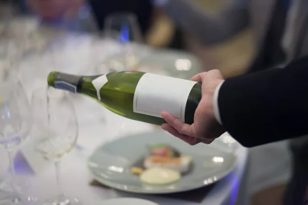 Kellner gießt Weißwein ins Weinglas im Restaurant. blu — Stockfoto