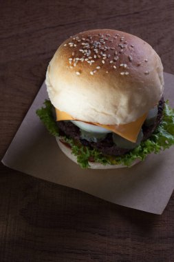 Sığır eti burger peynirli ahşap masa üzerinde Kapat.