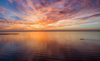 Mobile Bay, Alabama 'da gün batımında iki kayakçının hava görüntüsü. 