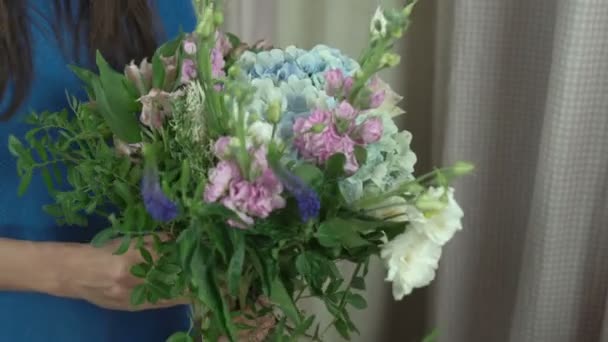 30s kvinnliga florist gör en bukett i en blomma salong närbild 4k. — Stockvideo