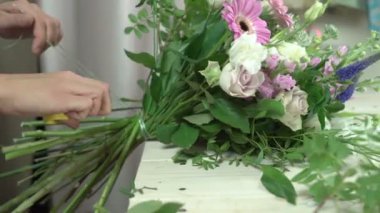 Çiçekçi bir buket bağlar ve makas 4 k yakın çekim aşırı bir dizeyle keser.