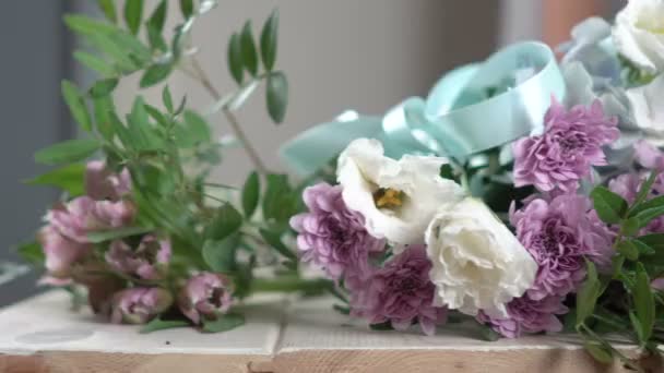在一家花店与蓝丝带特写 4 k 柜台上的花. — 图库视频影像