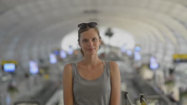 Giovane donna americana in posa per la foto in aeroporto interno mentre il viaggio asiatico . — Video Stock