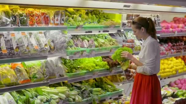 Bali, Endonezya - Mart 2019: Genç beyaz kadın süpermarketten taze yeşil salata ve organik sebzeleri seçiyor. — Stok video