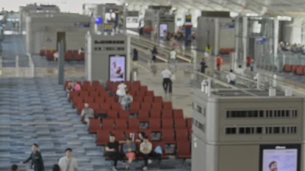 Міжнародний аеропорт чекає кімнату і мандрівника зверху розмитий розмитий вигляд. — стокове відео