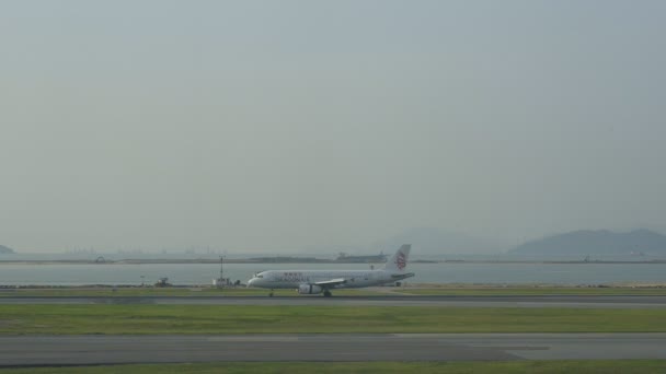 Hongkong, Chine - Août 2019 : Vue urbaine de l'avion dragonair se déplaçant le long de la piste et le navire sur la rivière dans la ville . — Video