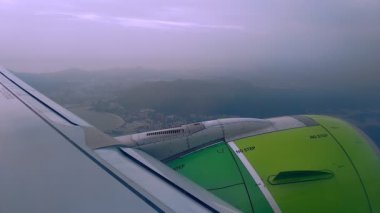 Uçak penceresi kanat ve türbinlerin karada uçtuğunu gösteriyor. Uçuştaki yolcu uçağı.