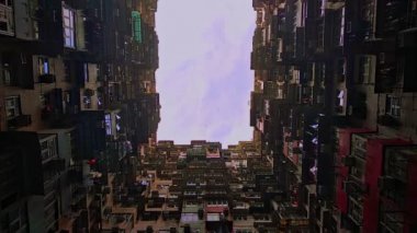 Hong Kong 'da çok sayıda insanın yaşadığı ünlü bir bina. Asya şehrinde yaz mevsiminde binanın ön cephesi ve mavi gökyüzünün alt manzarası.