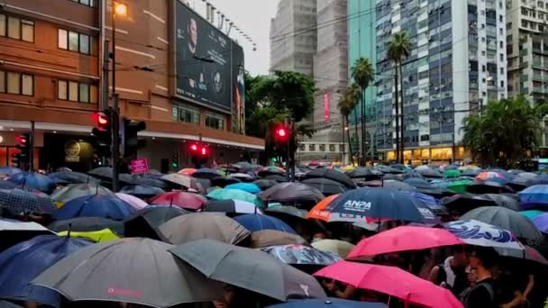 Hong Kong, Chiny - sierpień 2019: Ludzie z parasolami idą ulicą podczas protestu politycznego w Hongkongu. — Wideo stockowe