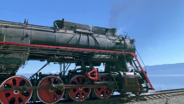 Lago di Baikal, Russia - Agosto, 2019: Locomotiva a vapore in piedi sulla ferrovia in zona naturale con montagne e mare — Video Stock