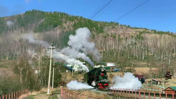 ロシアのバイカル湖- 8月, 2019:秋の日に田舎の鉄道駅に沿って移動する古い機関車 — ストック動画