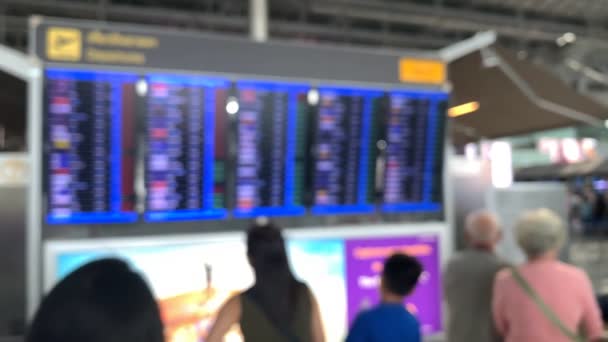 Fondo moderno aeropuerto bordo de vuelo de la llegada de pasajeros de salida. hombre con gafas y mujer de pie y mirar — Vídeo de stock