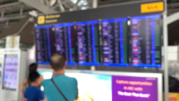到着出発旅客の近代的な空港フライトボードの背景。脱毛男と女が立って見て — ストック動画